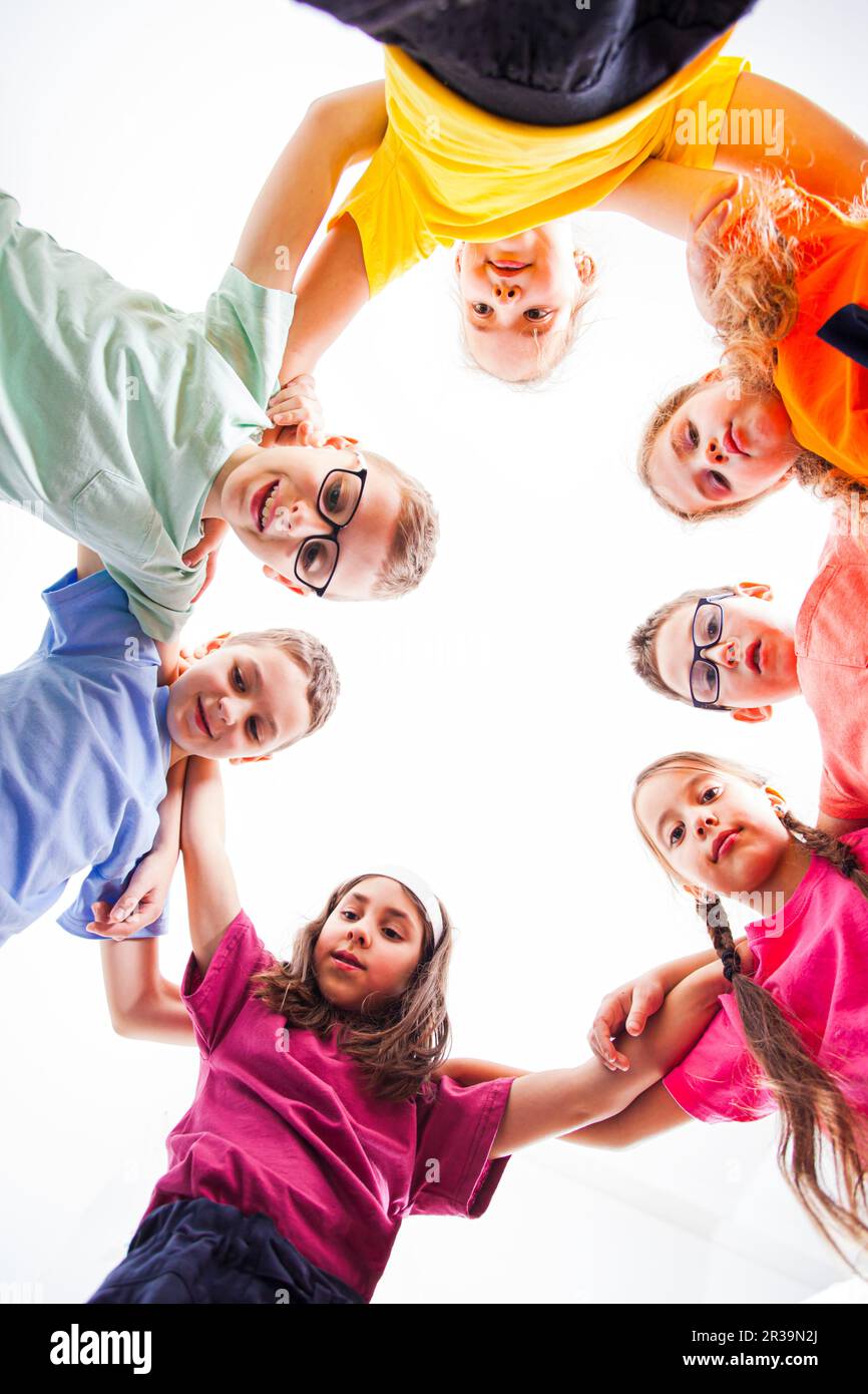 Sous la vue des enfants s'embrassant et souriant à l'appareil photo. Banque D'Images