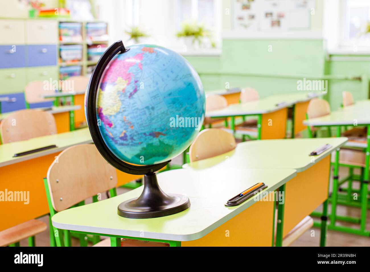 Globe terrestre sur le bureau jaune de la salle de classe Banque D'Images