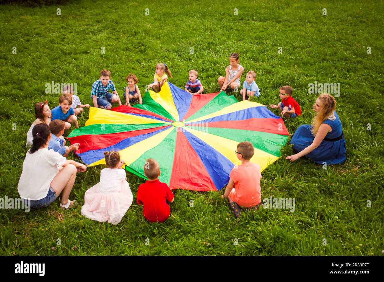 Grand groupe d'enfants jouant au jeu de parachute Banque D'Images
