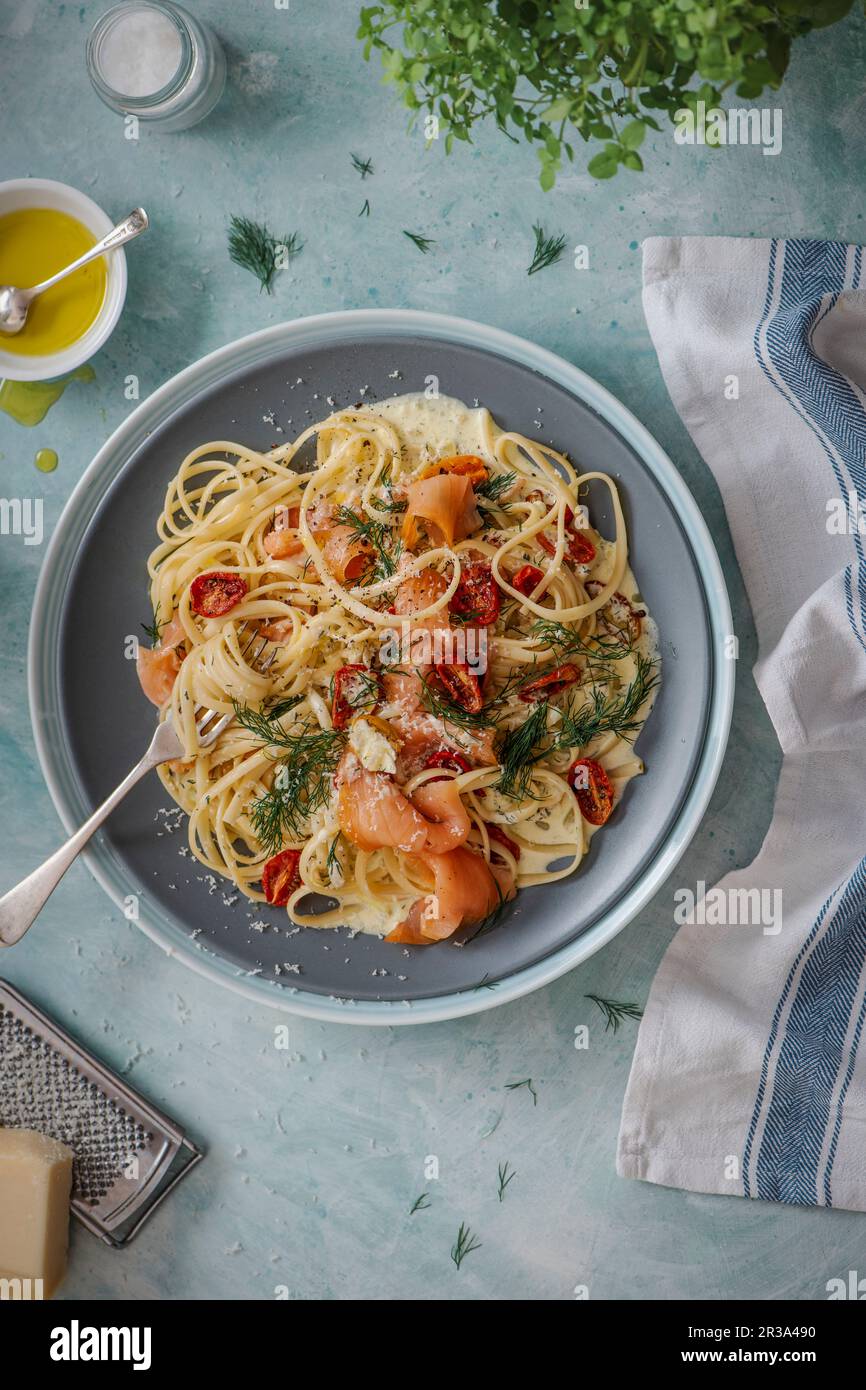 Pâtes au saumon fumé avec sauce crémeuse à l'ail et à l'aneth, tomates  cerises rôties et parmesan Photo Stock - Alamy