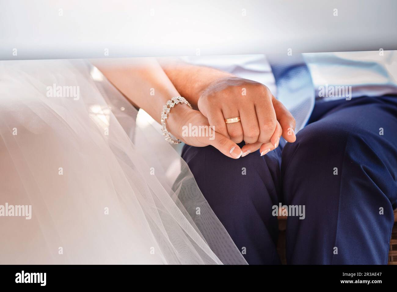 Mains de mariée et marié dans les anneaux de mariage sous le tableau Banque D'Images