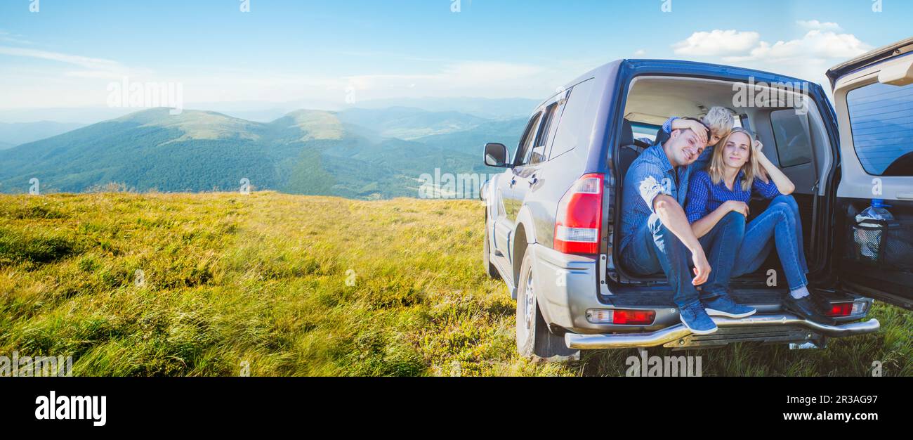 Famille assise dans le coffre de voiture pendant le voyage vers les montagnes Banque D'Images