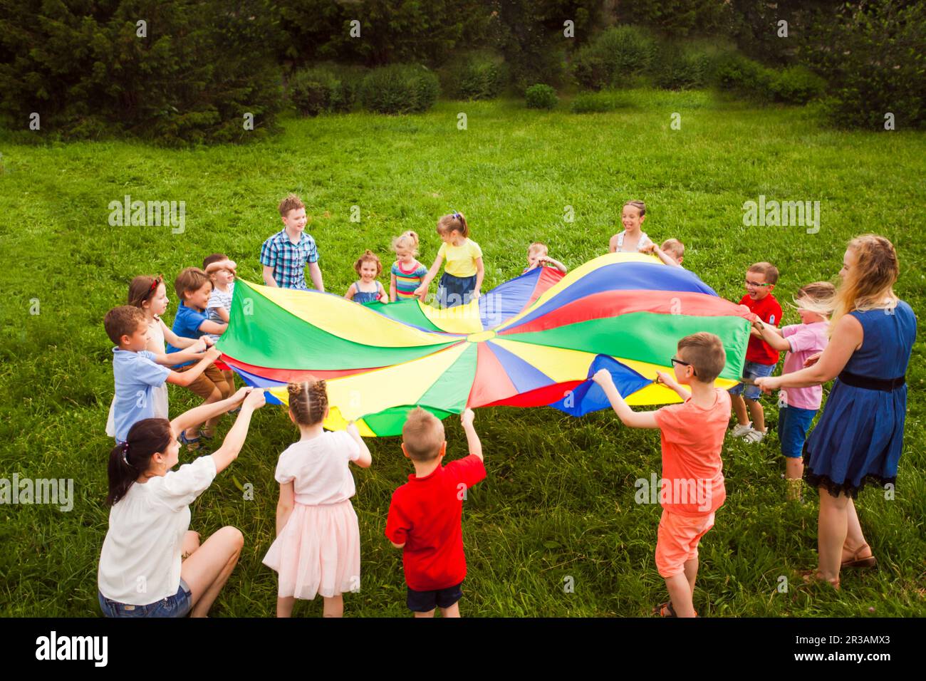 Jeux en plein air avec parachute coloré. Camp d'été Banque D'Images