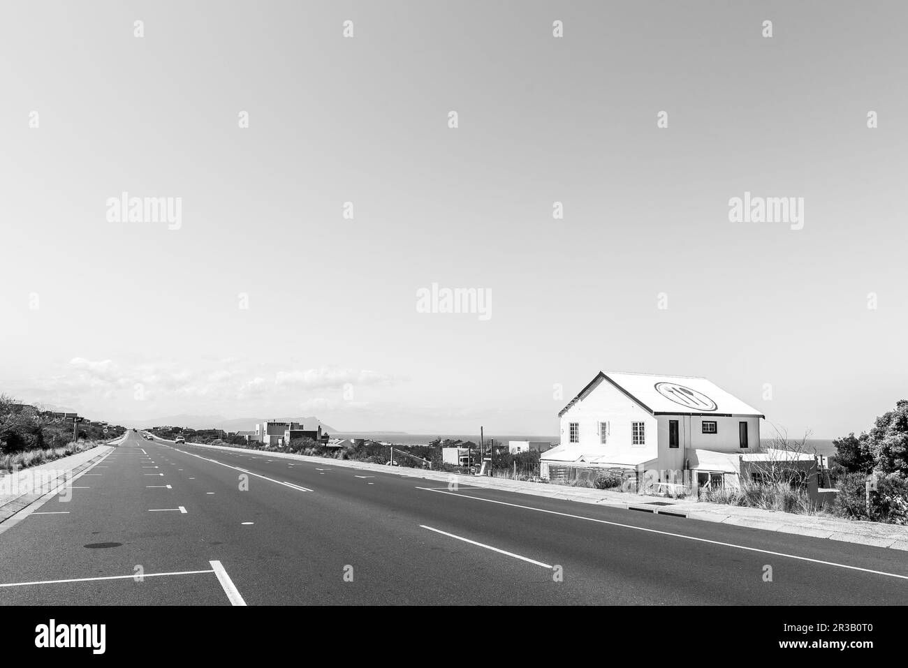 Bettys Bay, Afrique du Sud - 20 septembre 2022 : une scène de rue, avec des entreprises et des véhicules, à Bettys Bay, dans la province du Cap occidental. Monochrome Banque D'Images