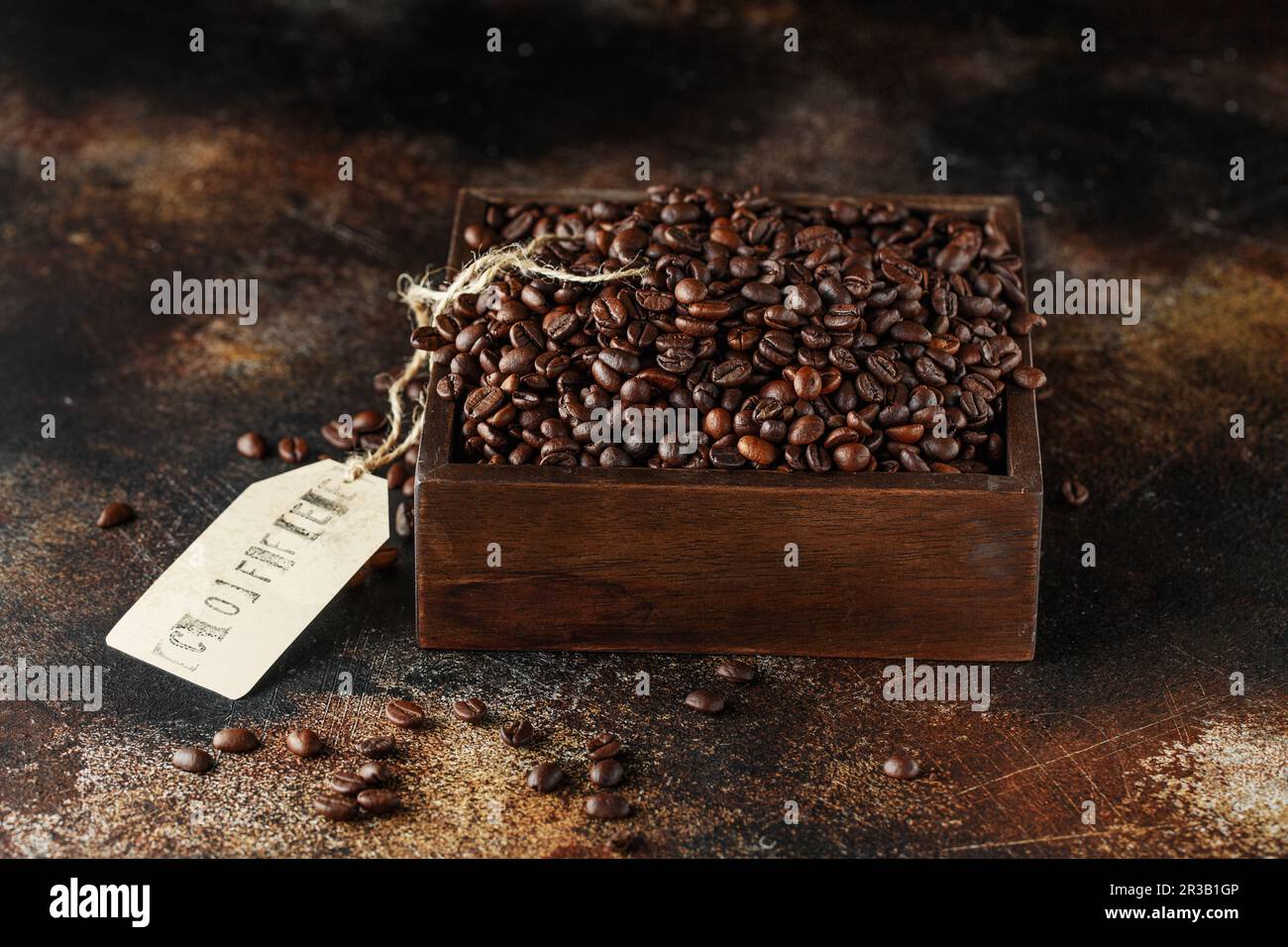 Grains de café noirs en studio. Grains de café fraîchement torréfiés dans une boîte en bois Banque D'Images