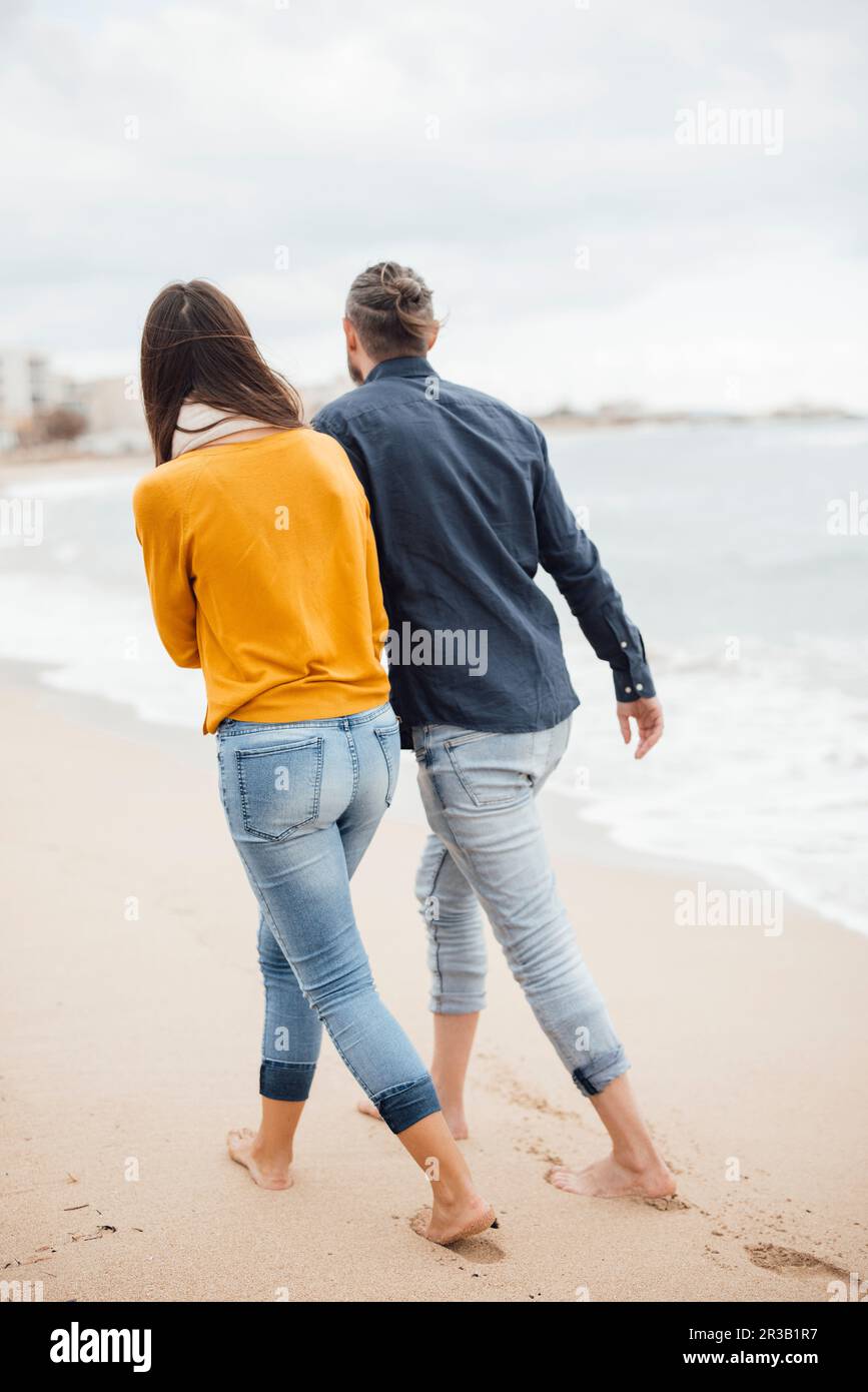 Homme et femme marchant ensemble à la plage Banque D'Images Homme et femme marchant ensemble à la plage Banque D'Images