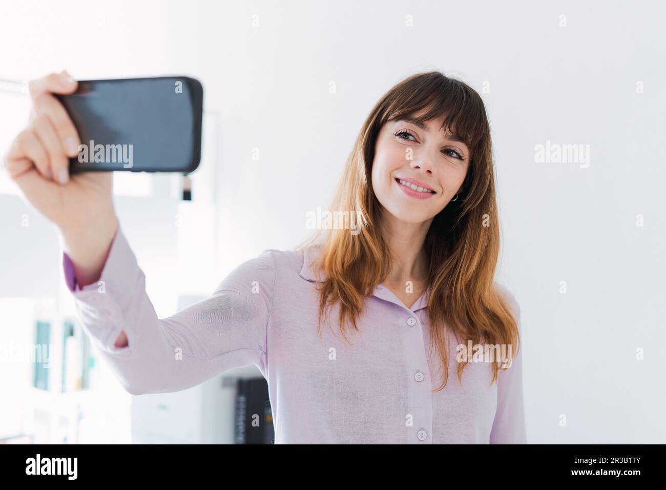 Femme souriante prenant le selfie par smartphone Banque D'Images