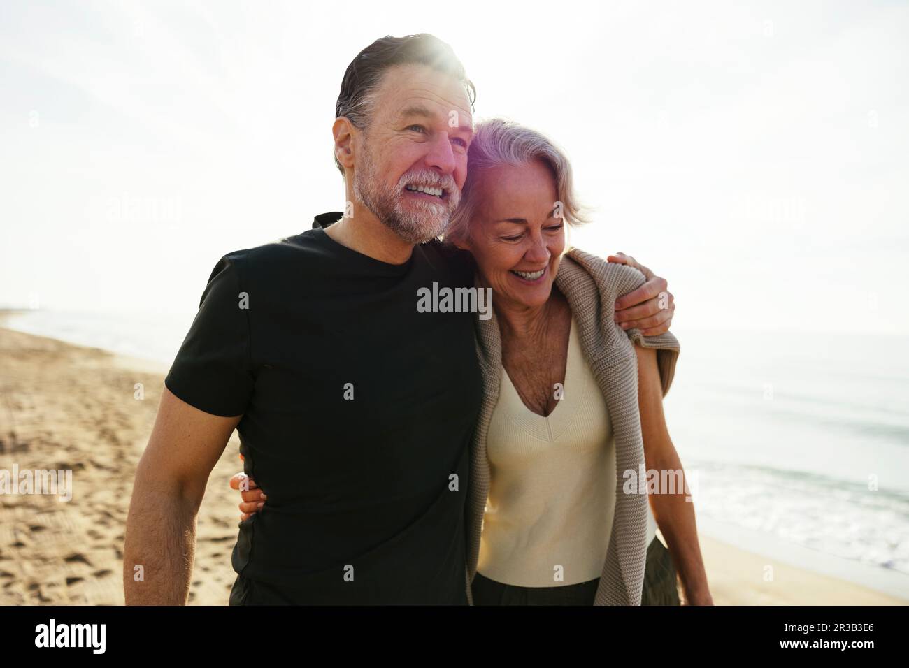 Homme heureux avec le bras autour de la femme à la plage Banque D'Images