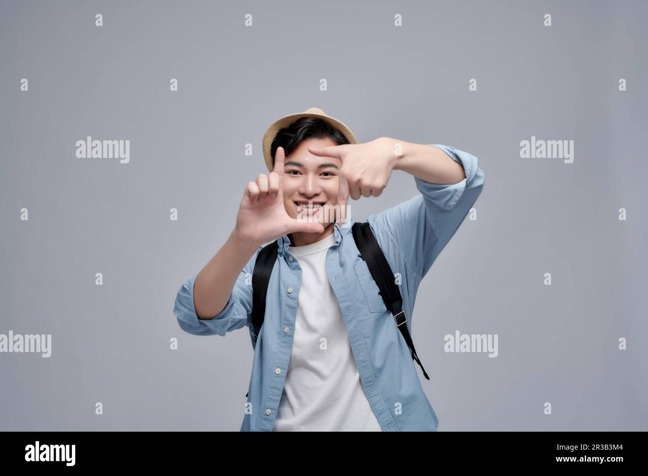 Photo de charmant jeune homme attrayant faire des doigts cadre image sourire Banque D'Images