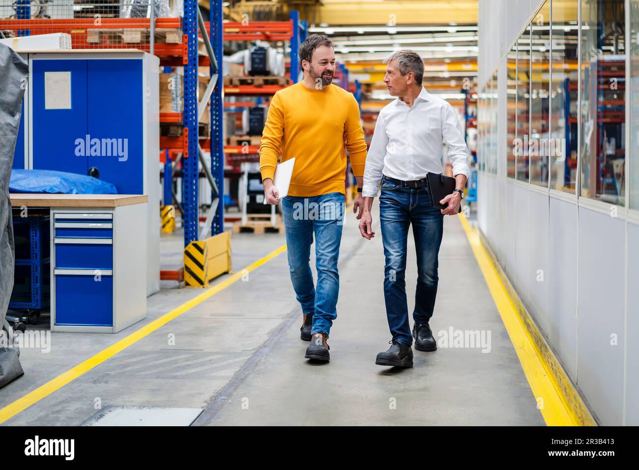 Les hommes d'affaires marchent ensemble dans l'usine Banque D'Images Les hommes d'affaires marchent ensemble dans l'usine Banque D'Images