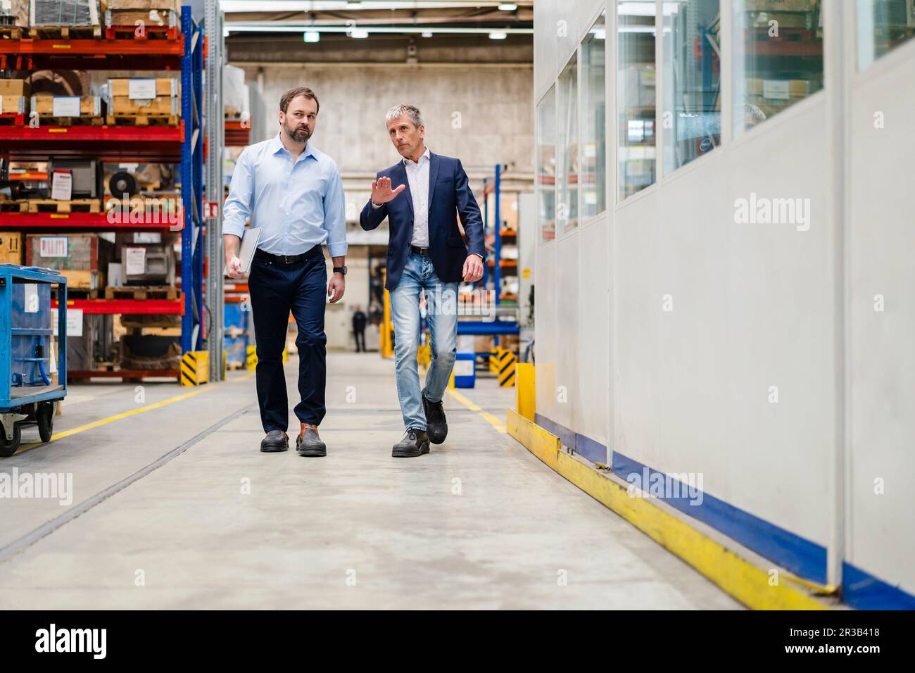 Homme d'affaires et directeur qui marchent ensemble à l'usine Banque D'Images Homme d'affaires et directeur qui marchent ensemble à l'usine Banque D'Images