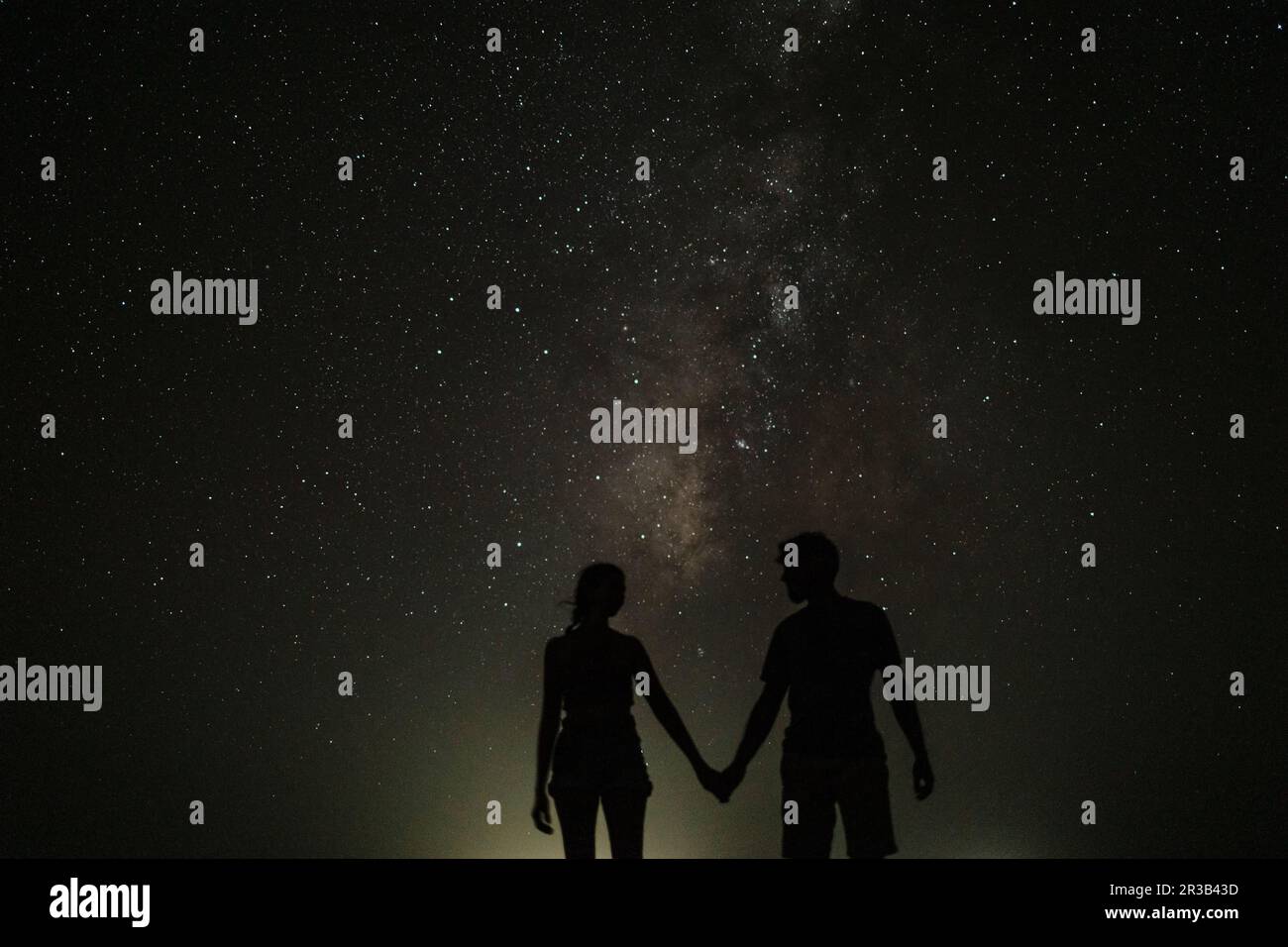 Silhouette de couple tenant les mains debout la nuit Banque D'Images