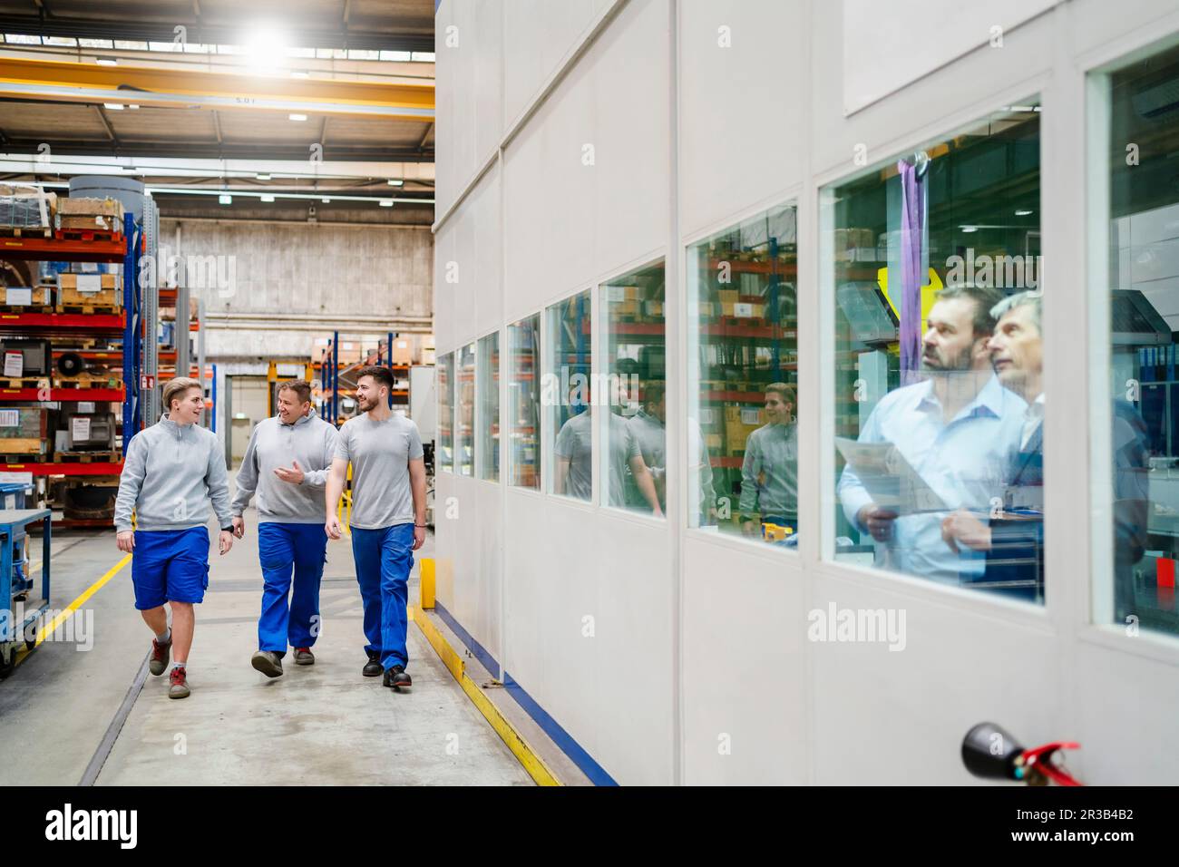 Les employés se rassemblent dans le hall de production de l'usine Banque D'Images Les employés se rassemblent dans le hall de production de l'usine Banque D'Images
