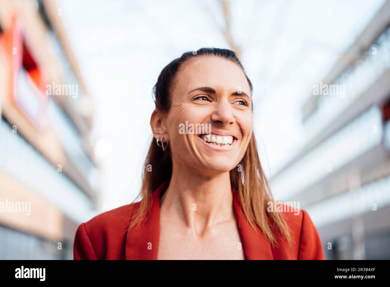 Femme d'affaires contemplative avec un sourire charmeur Banque D'Images