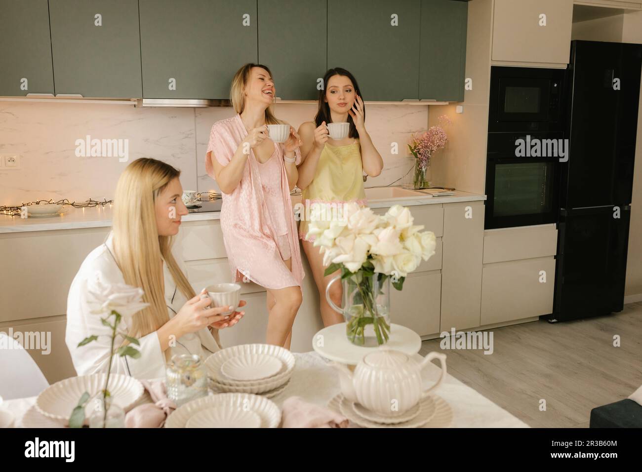 Des amis heureux prenant des boissons dans la cuisine à la maison Banque D'Images