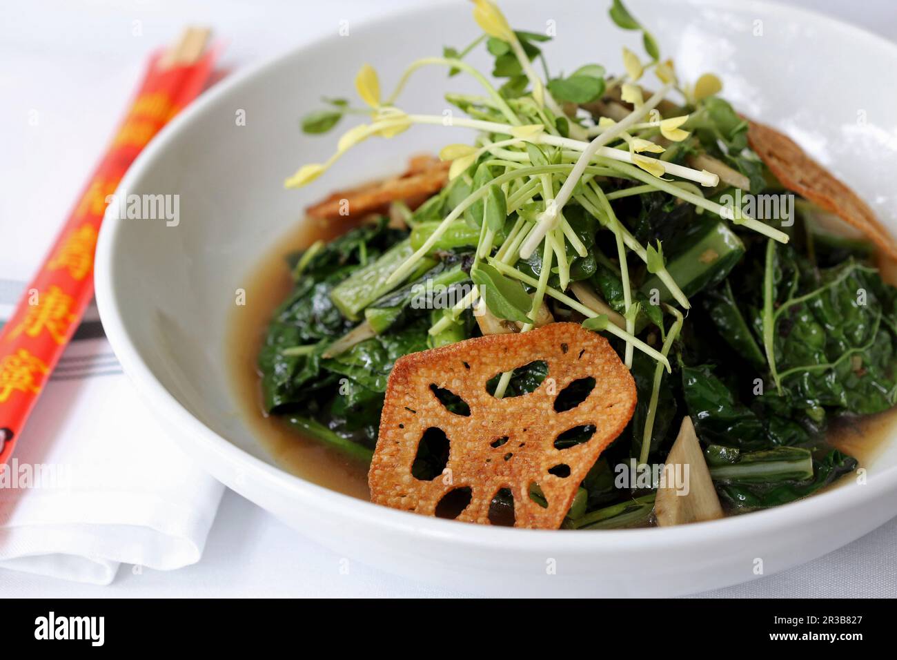 Légumes verts à la moutarde conservés, gingembre, bouillon maison de qualité supérieure avec garniture de copeaux de lotus Banque D'Images