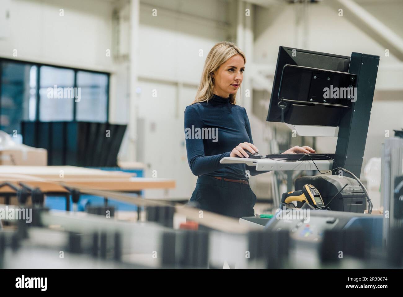 Femme d'affaires travaillant sur un PC de bureau dans l'usine de menuiserie Banque D'Images