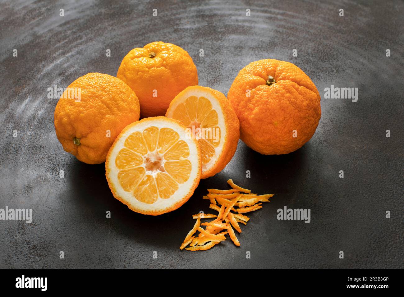 Oranges amères fraîches avec zeste sur métal noir Banque D'Images