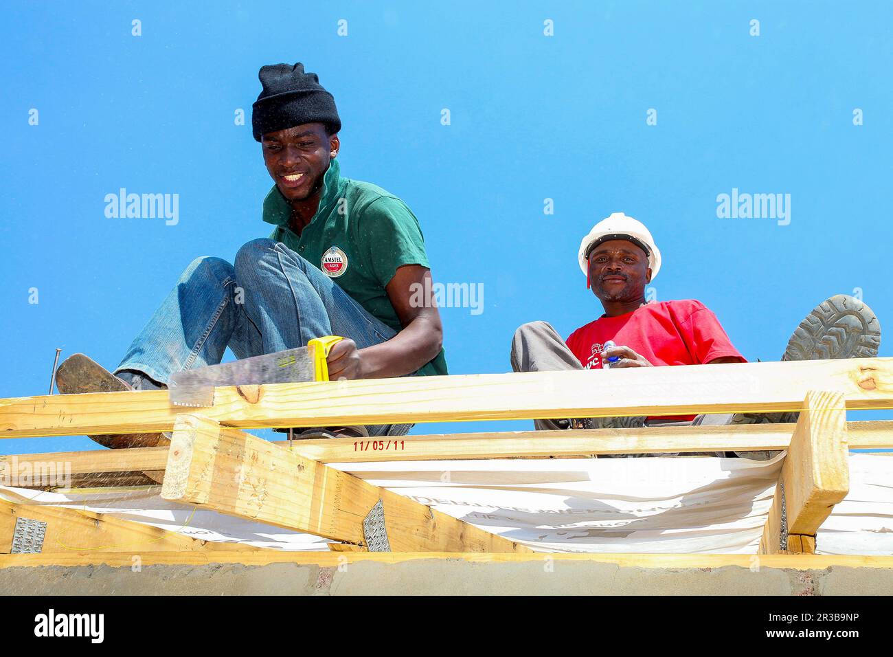 Divers membres de la communauté construisent une maison à faible coût à Soweto Banque D'Images