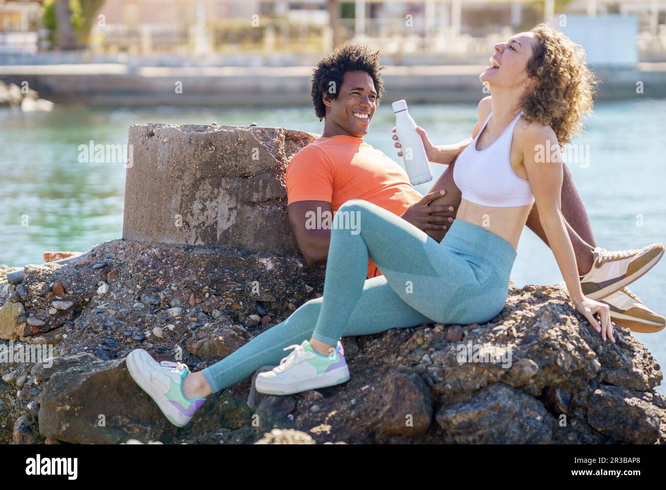 Couple rire et se détendre sur le rocher près de la mer dans la région côtière Banque D'Images