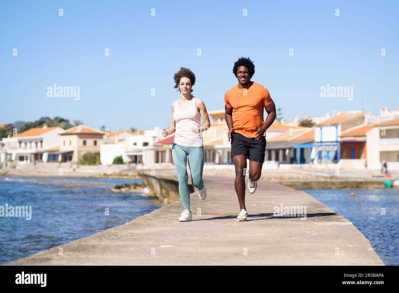 Couple en train de courir sur la jetée près de la mer dans la région côtière Banque D'Images