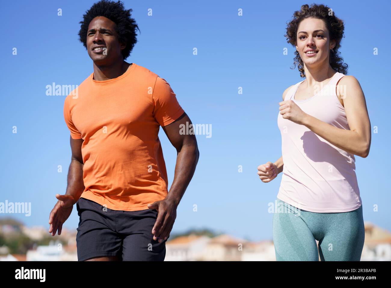 Couple souriant qui court dans la zone côtière Banque D'Images