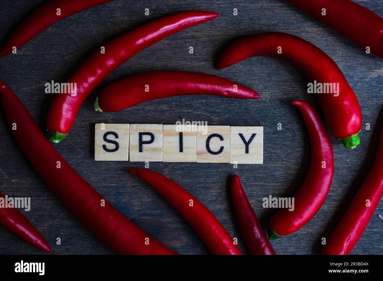 Concept de cuisine avec piments rouges chauds en forme de coeur avec blocs de bois ÉPICÉS sur table en bois avec espace de copie Banque D'Images