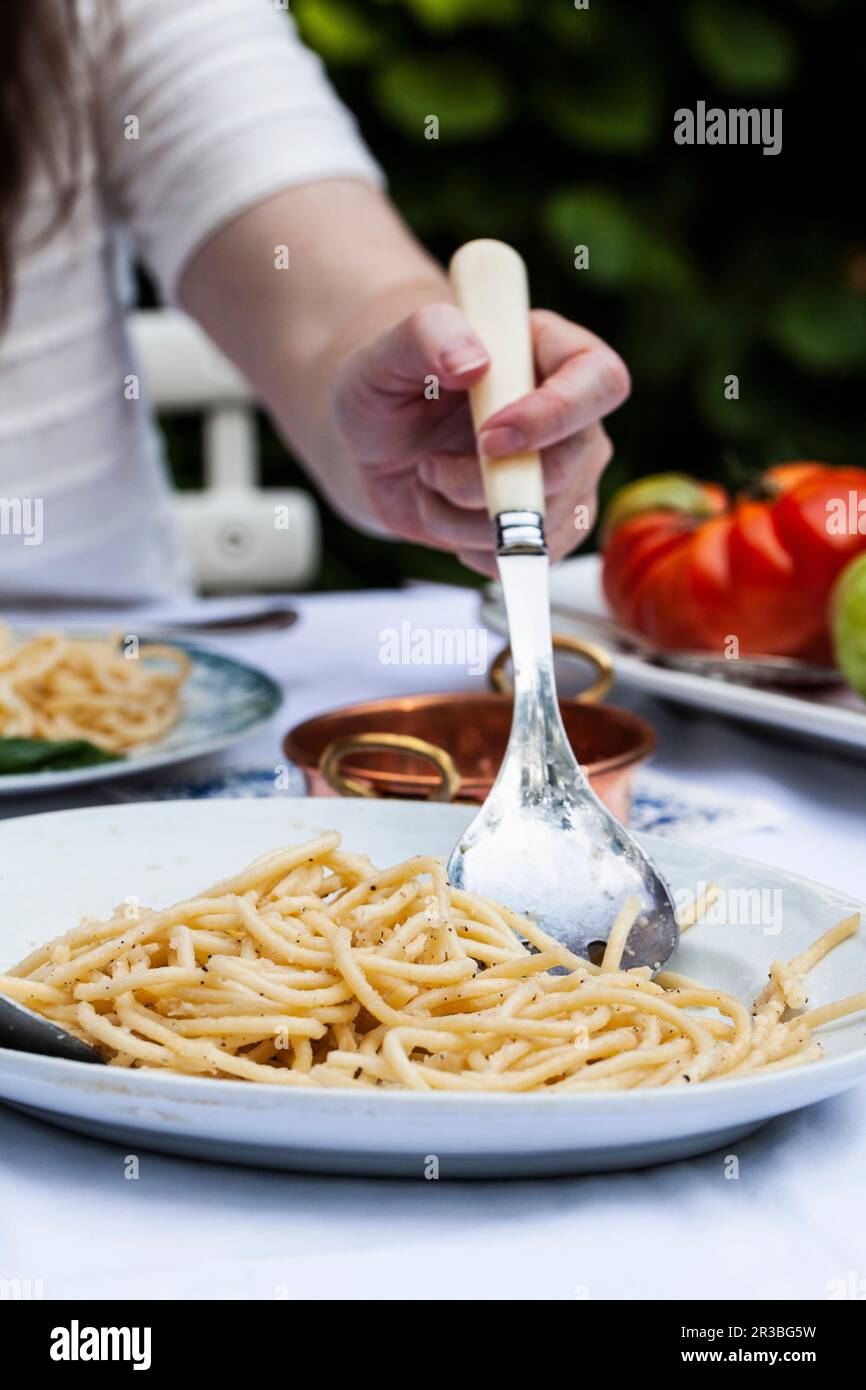 Un plateau de pâtes cacio e pepe servi (pâtes au fromage et au poivre) une table extérieure Banque D'Images