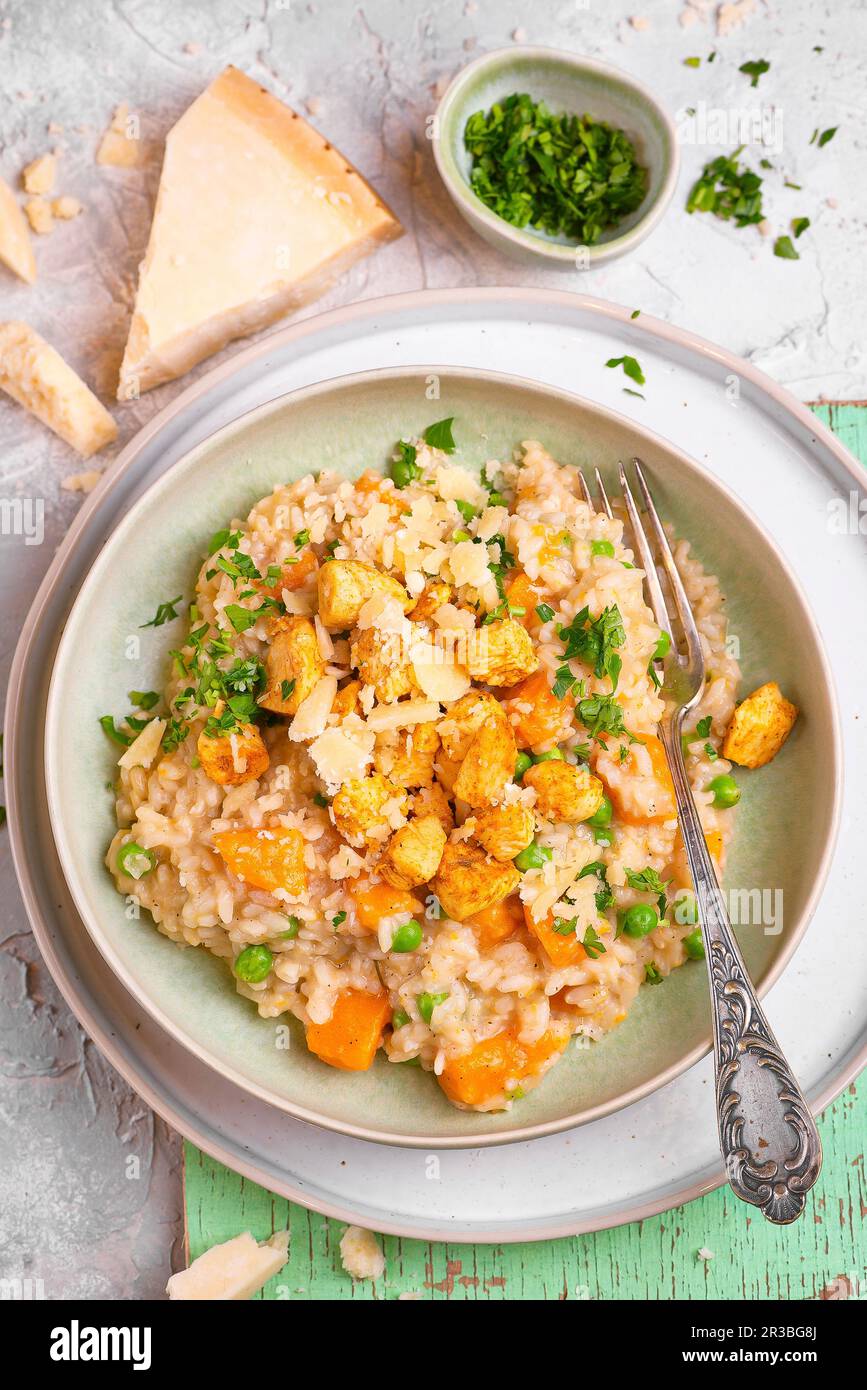 Risotto à la citrouille, au poulet et aux pois verts Banque D'Images