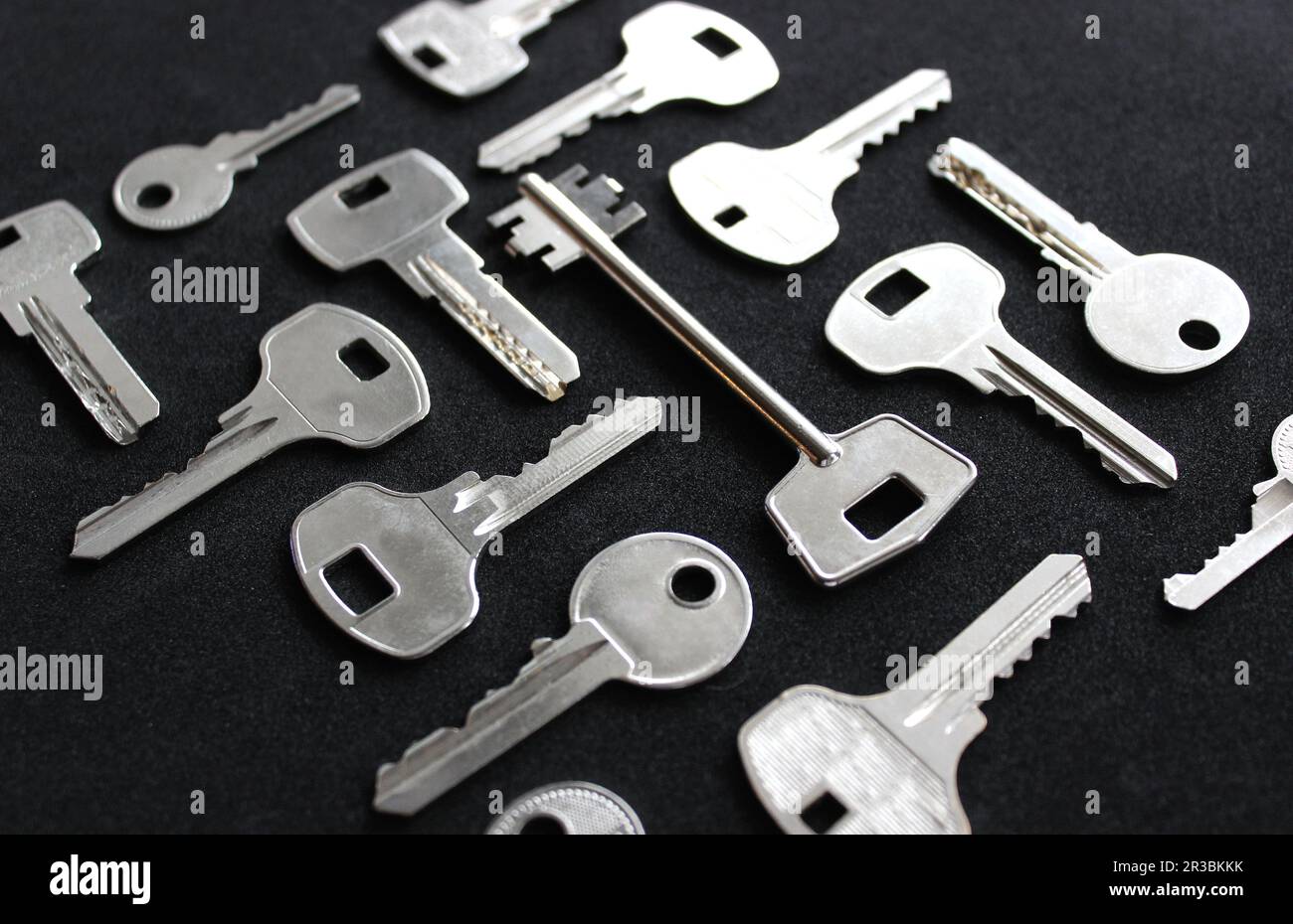 Variété de types de clés métalliques disposées dans l'ordre isolé sur la vue d'angle noir Banque D'Images
