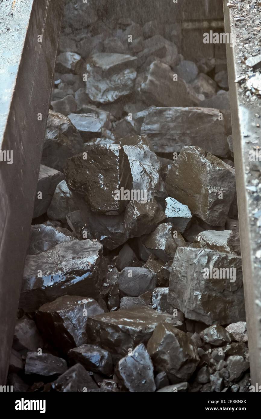 Gros plan de la roche de manganèse sur un tapis convoyeur Banque D'Images