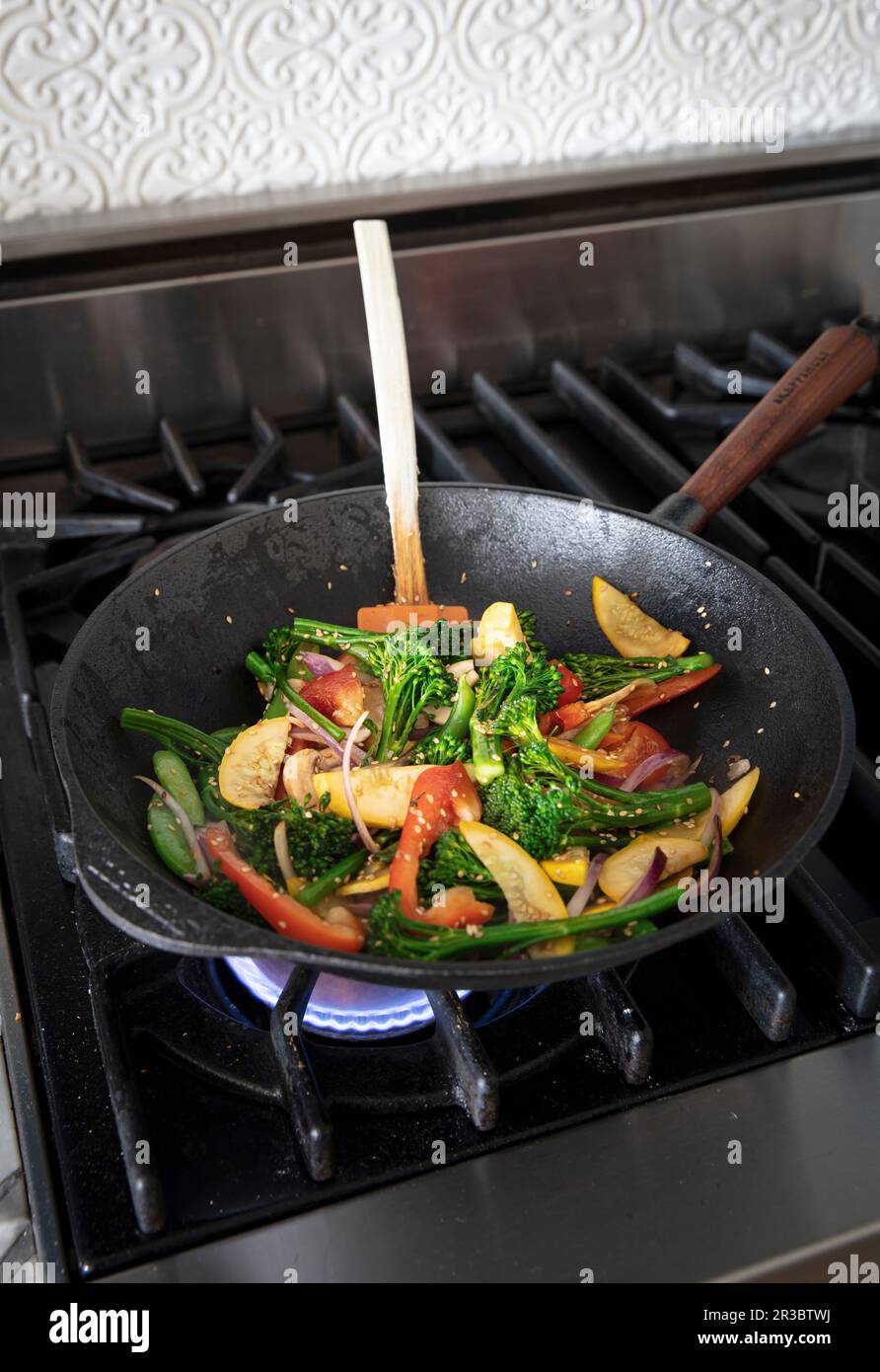 Faites frire les légumes dans la poêle tout en remuant Banque D'Images