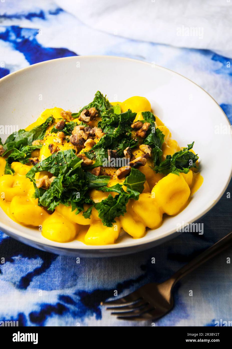 Bol de pâtes gnocchi dans une sauce à la citrouille avec du chou frisé et des noix Banque D'Images