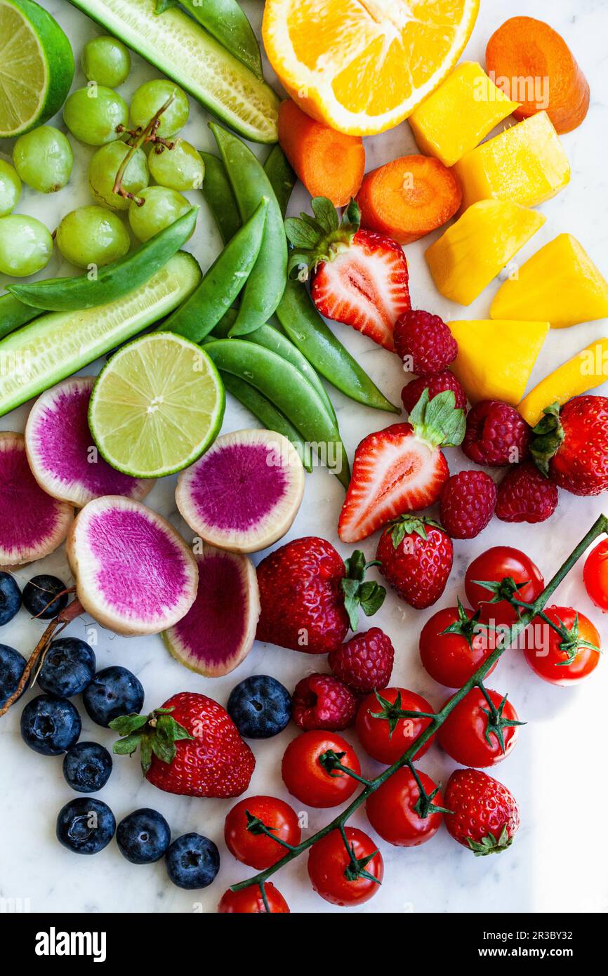 Divers fruits et légumes, disposés en couleur sur un comptoir en marbre Banque D'Images
