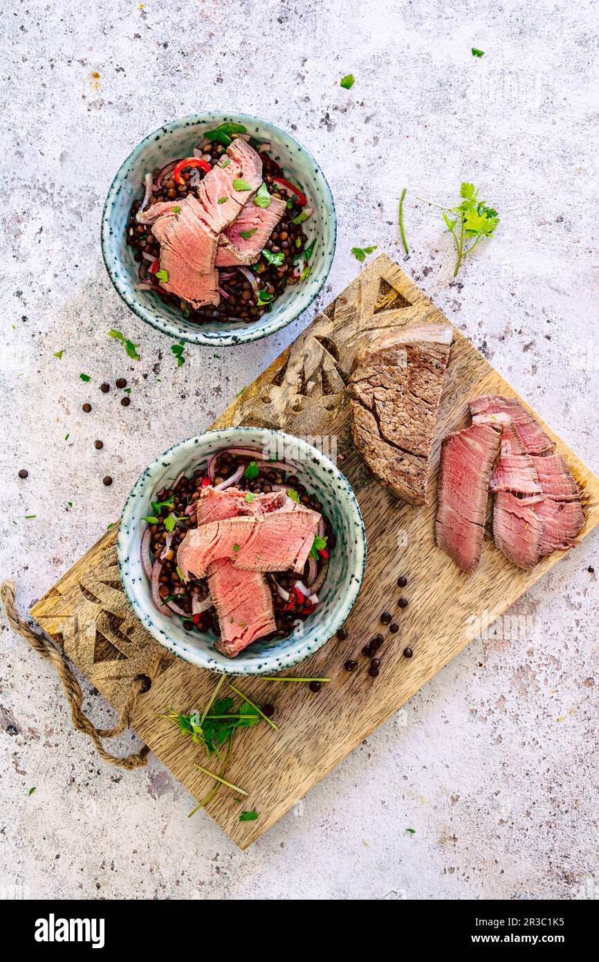Dans un pot, mettre en salade les lentilles de béluga et les filets de bœuf Banque D'Images