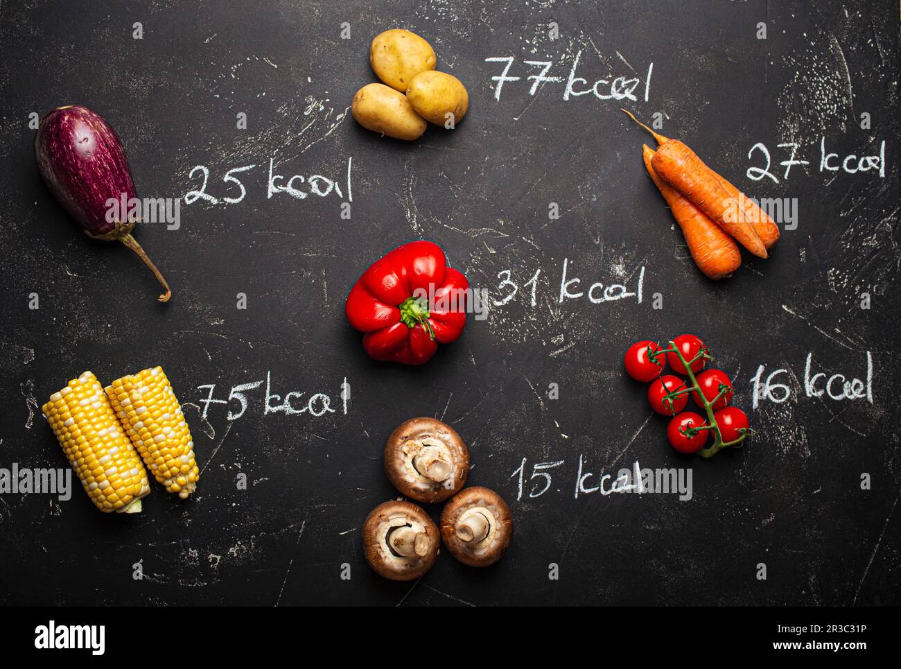 Différents légumes sur fond de pierre noire et craie ont écrit quantité de calories Banque D'Images