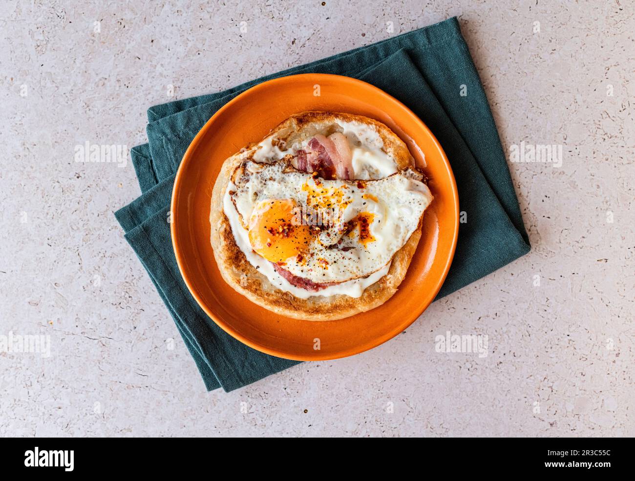 Paratha avec yaourt à l'ail, œuf frits, bacon et huile de Chili Banque D'Images