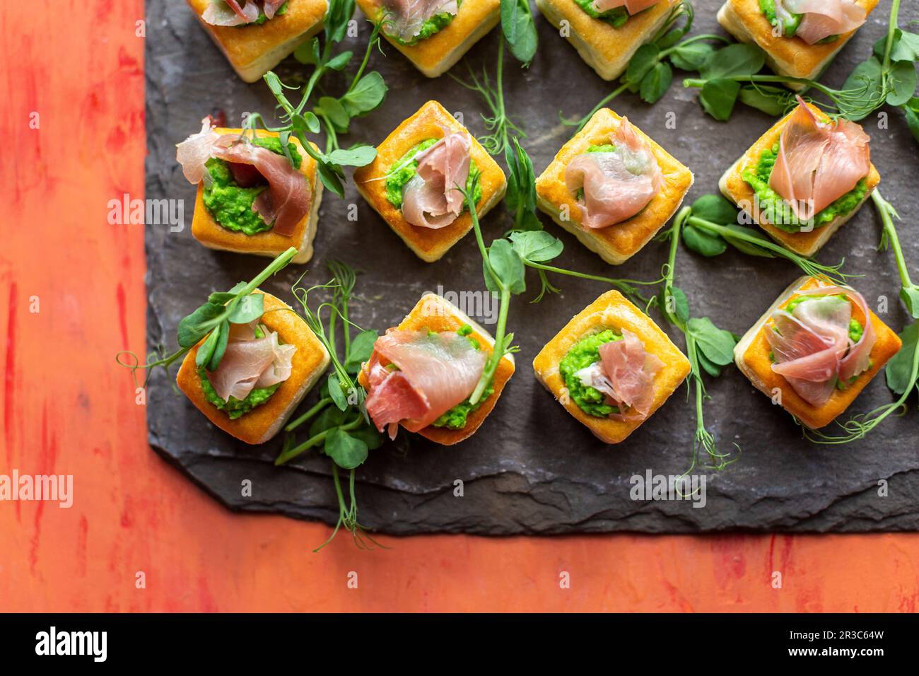 En-cas de pâte feuilletée avec jambon de Parme, purée de pois et pousses de pois Banque D'Images