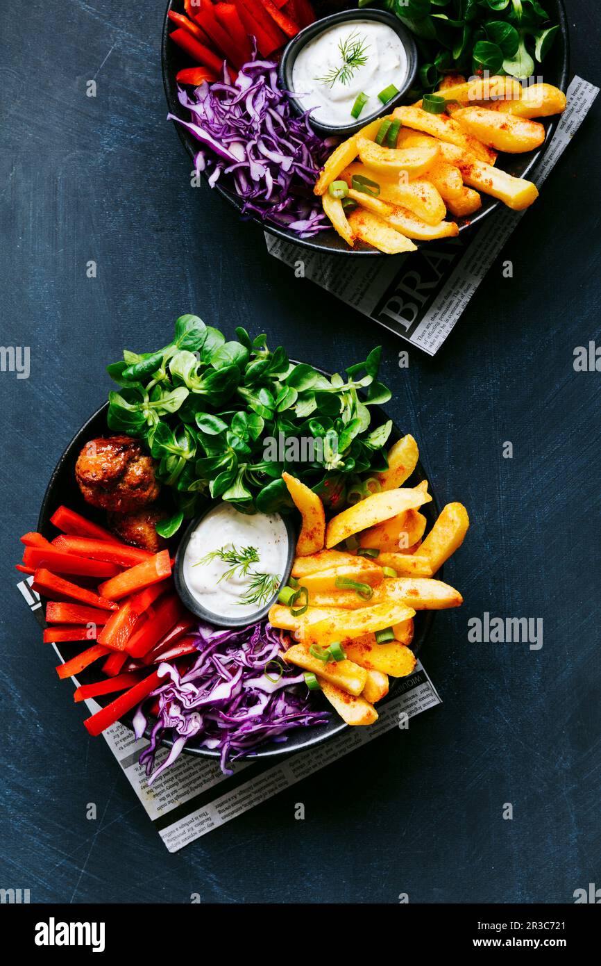 Bol végétarien coloré avec quartiers de pommes de terre et « petits boulettes » végétaliennes Banque D'Images