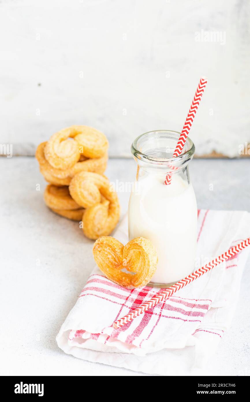 Biscuits traditionnels en spirale de pâte feuilletée appelés oreilles de porc sur l'assiette avec du sucre Banque D'Images