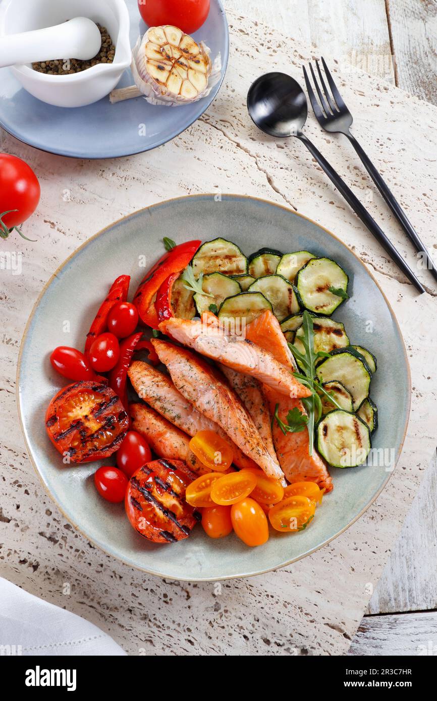 Morceaux de saumon cuits servis avec des légumes grillés Banque D'Images