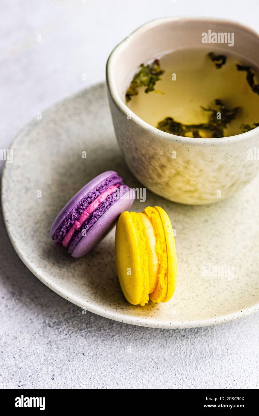 Tasse de thé vert au soursop et de pâte de macaron sur fond de béton Banque D'Images