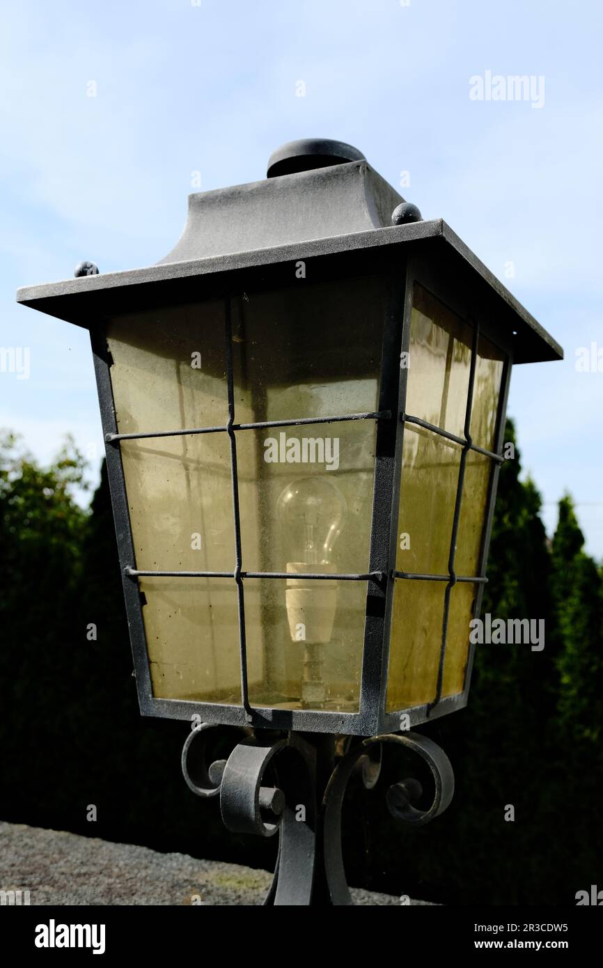 Une lanterne ancienne, éfaite par le temps, émettant une lueur douce et ajoutant un charme nostalgique aux rues et aux espaces extérieurs. Banque D'Images