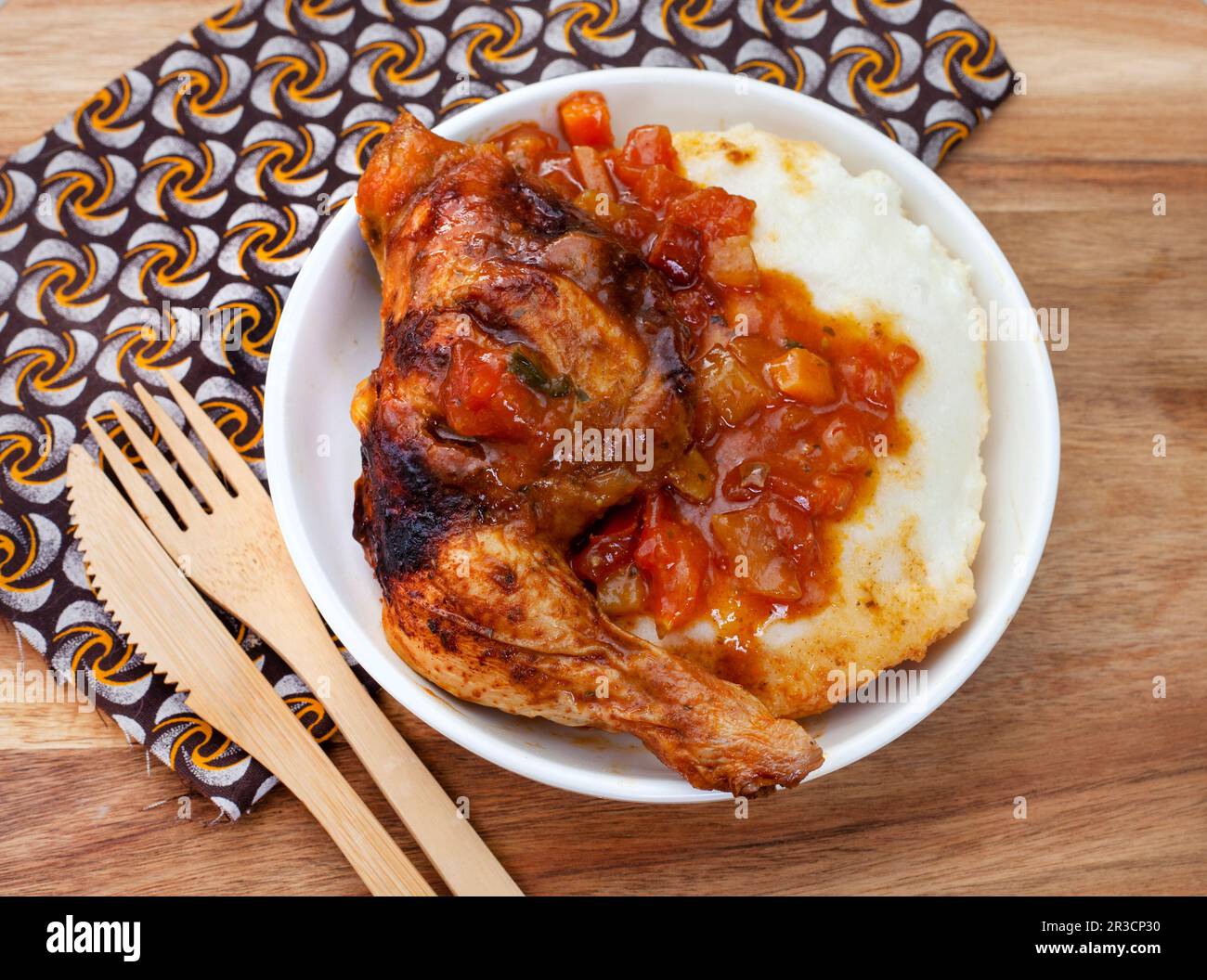 Repas traditionnel sud-africain de pap ou de maïs avec sauce traditionnelle de tomate et d'oignon sur du textile traditionnel Banque D'Images