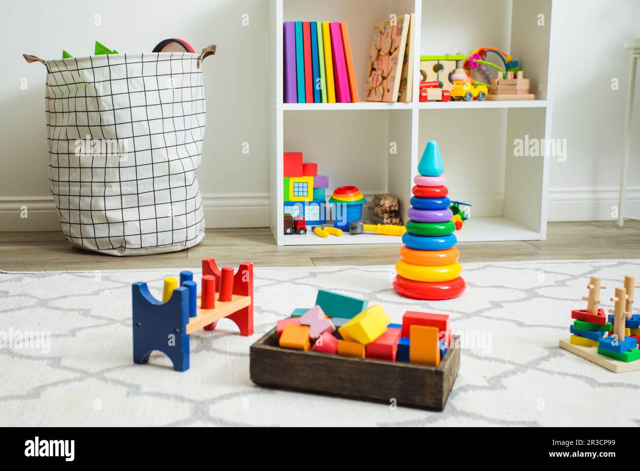 Jouets colorés sur moquette blanche dans la chambre des enfants Banque D'Images