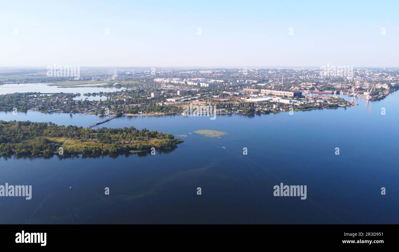 Un drone survole la rivière de l'eau, entourée d'une ville industrielle avec divers bâtiments et Wetland et mar Banque D'Images