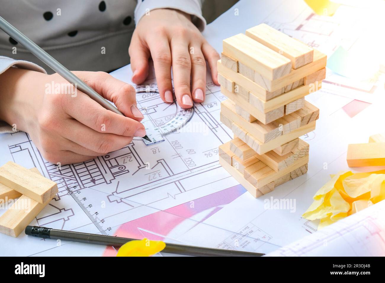 Architecte designer intérieur créatif travail main jouant un jeu de bois de bloc sur le bureau plan architectural de la maison, un PAL de couleur Banque D'Images