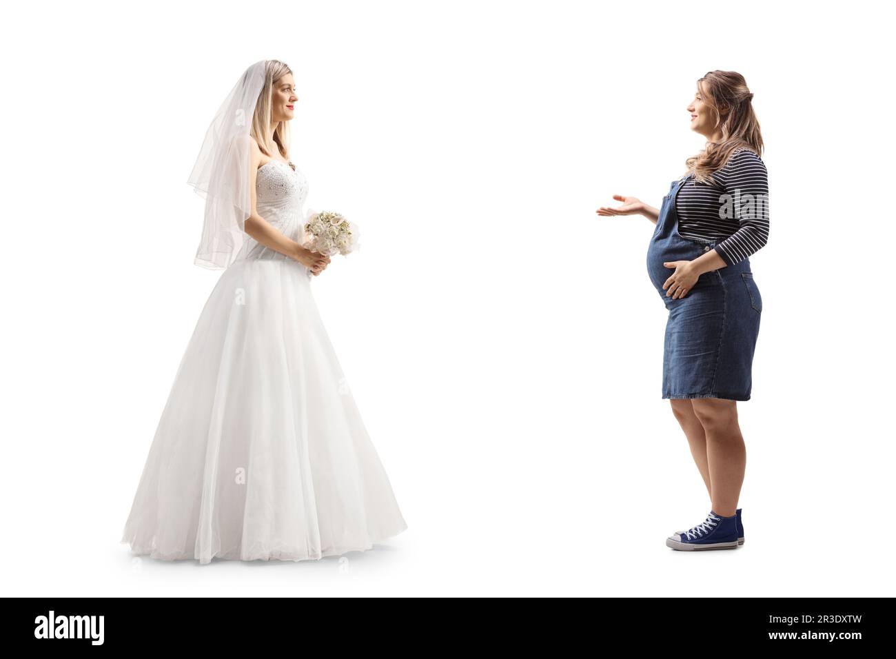 Photo de profil pleine longueur d'une mariée et d'une femme enceinte ayant une conversation isolée sur fond blanc Banque D'Images