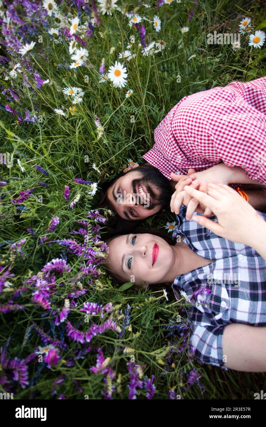 Couple romantique amour moment dans le champ parmi les fleurs sauvages Banque D'Images