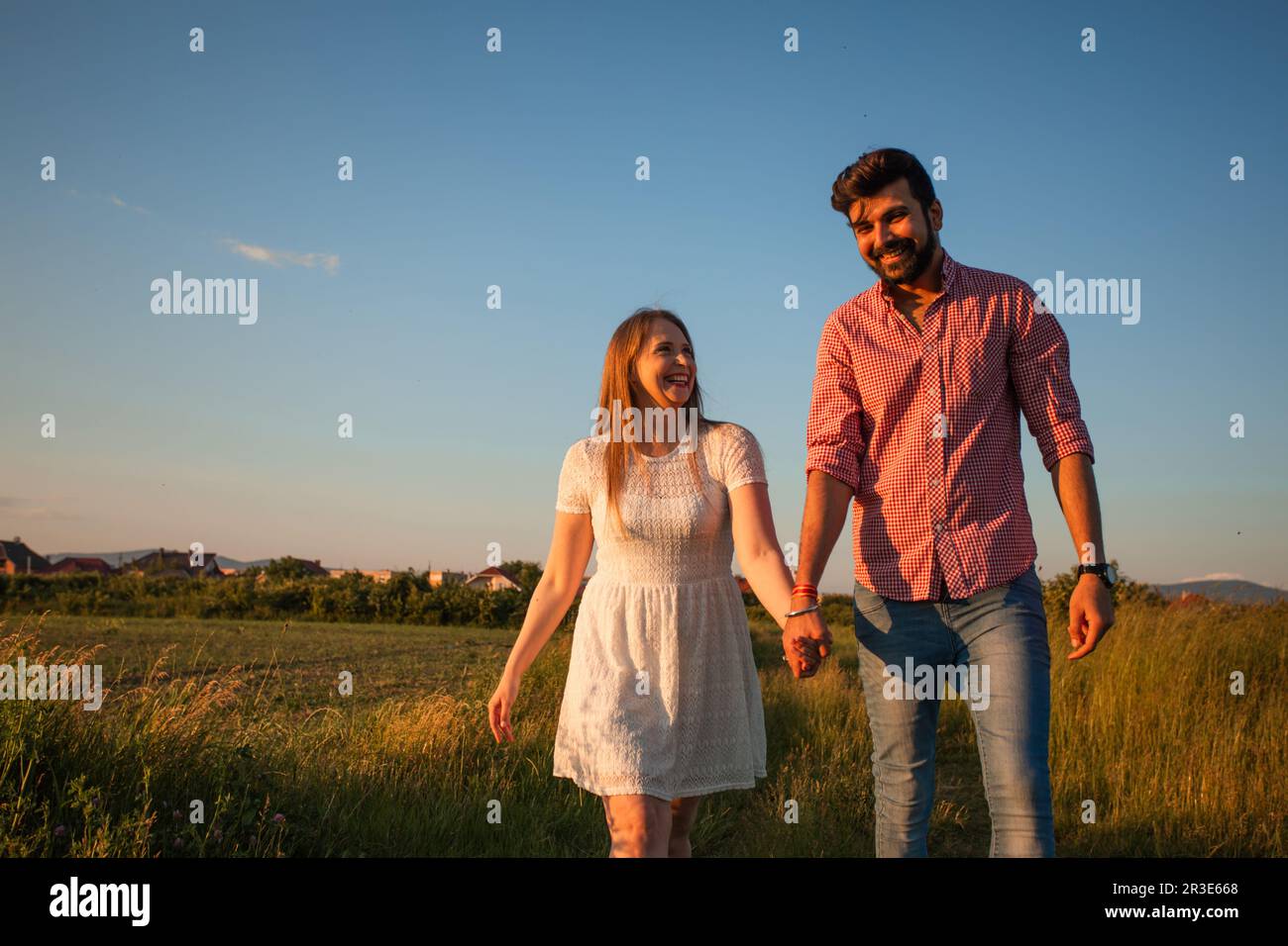 Un couple charmant qui marche dans le champ d'été Banque D'Images